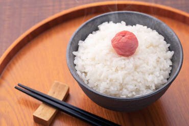 Rice and pickled plums on a wooden table