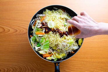It is made with yakisoba noodles, pork, sprouts, cabbage, and carrots.